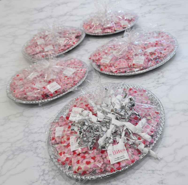 Trays of candy with decorative packaging on a marble surface